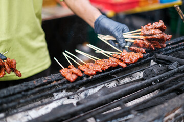 Grilling Skewered Meats at Outdoor Market Stall