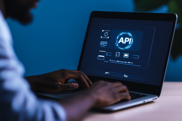 African male adult using laptop to develop integration api on software interface