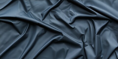 Obraz premium Textured dark blue fabric with elegant folds and creases.