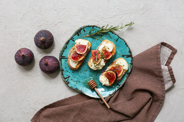 Plate of delicious fig bruschetta with ricotta cheese and rosemary on white background