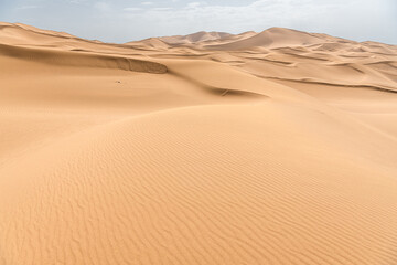 Rolling sand dunes, striped lines, beautiful silhouettes, in the Kumtag desert, Xinjiang, China