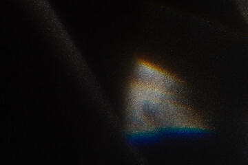 Rainbow sun flares on black background, colorful glare and shine, light rays on sparkling surface. Rainbow refraction of bright sunlight on dark fon. Natural light effects, trend aesthetic