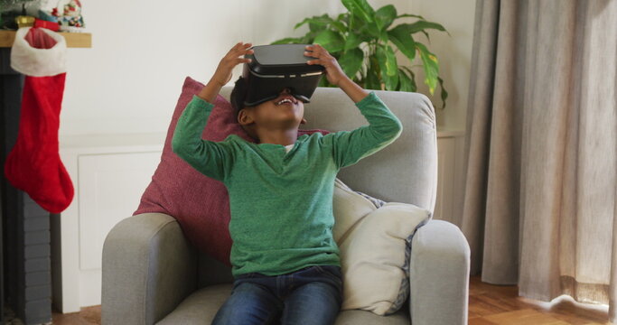 Happy african american boy wearing vr headset and having fun at christmas time