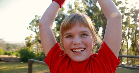 Happy girl cheering in boot camp during obstacle course