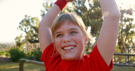 Happy girl cheering in boot camp during obstacle course