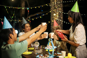 Group of Friends Toasting Drink Celebrating Birthday Outdoors at Night