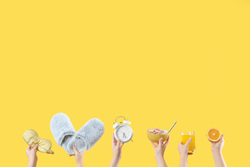 Female hands with sleeping mask, slippers, alarm clock and breakfast on yellow background. Good...