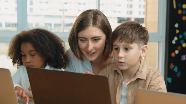 Smart teacher teaching and looking student using laptop at classroom. Professional instructor explained about programing engineering code or prompt while studying and learning program. Erudition.