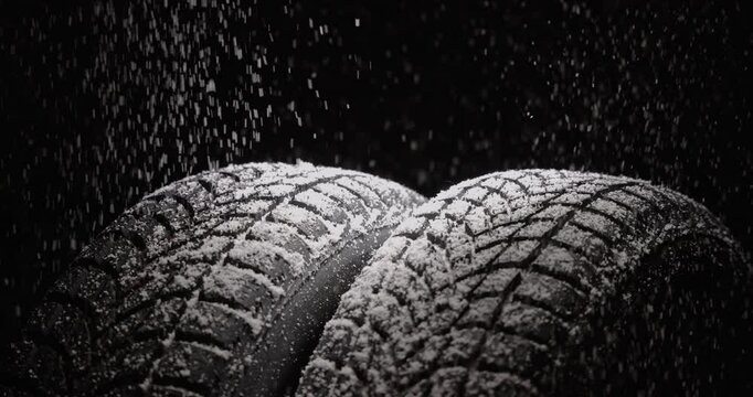 Winter Car tire with snow on black background. Tyre service and snowflakes video