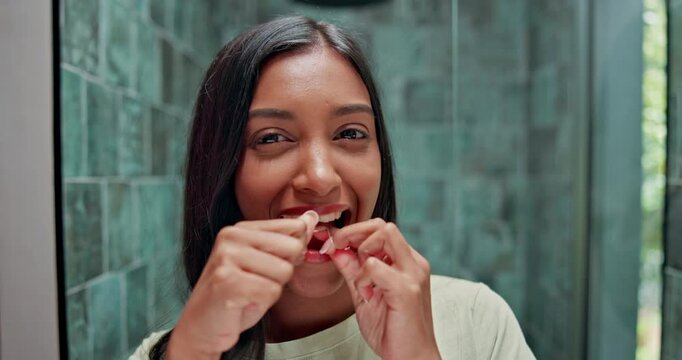 Happy woman, teeth and cleaning with dental floss for hygiene, morning routine or fresh breath. Portrait, female person or indian with smile for oral healthcare, mouth or gum care in bathroom at home
