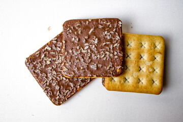 Sandwich biscuits with chocolate filling and coconut sprinkles on white background