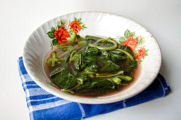 Sayur Bening Bayam Merah or Red Spinach Clear Soup served in a white bowl