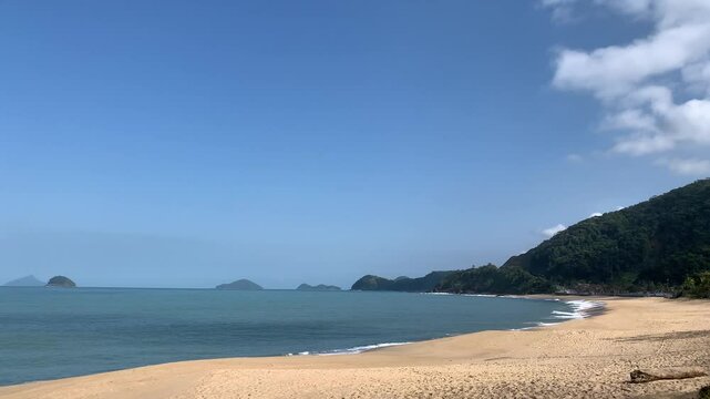 Sol e praia vazia. Atr&aacute;s, uma montanha de Mata Atl&acirc;ntica, carros na rodovia Rio-Santos e quatro ilhas famosas do litoral norte: Ilha Mont&atilde;o de Trigo, Ilha dos Gatos, Ilha das Couves e Ilha As Ilhas