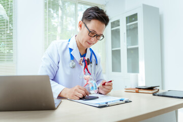 A male doctor sits at a desk in a hospital, discussing male urinary tract models and conditions like enlarged prostate, prostatitis, cystitis, urinary tract infections.Early diagnosis aids effective