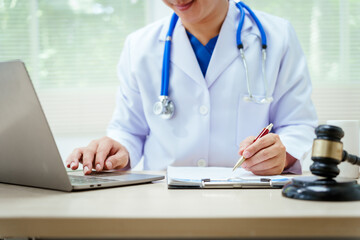 A male doctor sits at a desk, holding a signature pen, discussing medical law. This law safeguards patients and medical institutions during examinations and treatments, ensuring ethical healthcare