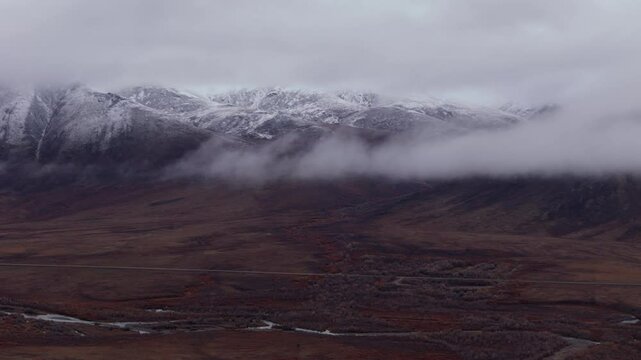 Low Clouds Over Snow Mountains Of Ogilvie Along The Dempster Highway In Yukon, Canada. Aerial Shot