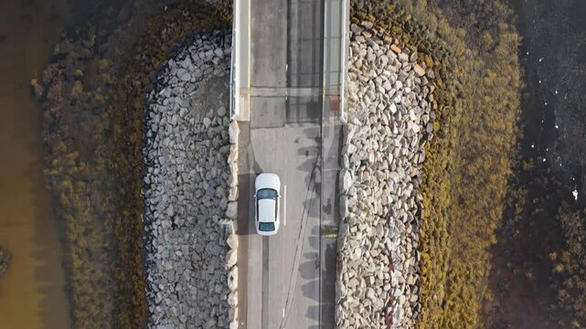 Electric car driving on the kyle of tongue causeway top down view