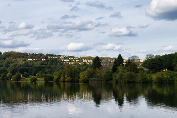 Lake with houses on a hill in the background on a summer day in Germany.