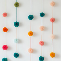 Hanging colorful pompom decorations on a white wall