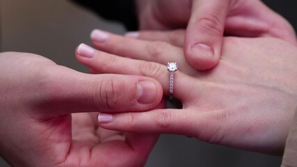 Capturing a romantic outdoor proposal with a closeup of the engagement ring being placed on the finger, symbolizing the start of a new journey and a special moment for the couple