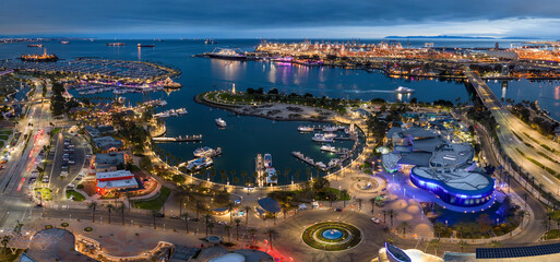 Panorama of Long Beach Rainbow Harbor at dusk with boats docked in a circle.

