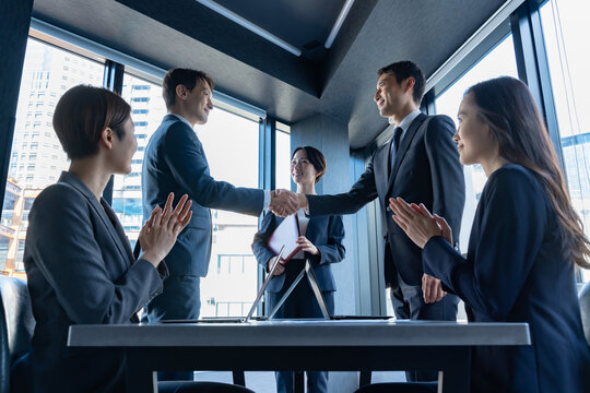 室内で握手をするビジネスマン