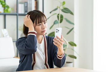 スマホで悩む若い女性