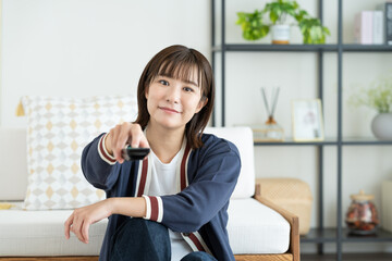 リビングでテレビを見る若い女性