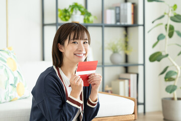 通帳を見る若い女性