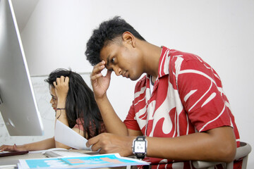 Young Asian Female And Male College Students Touching Their Head Feeling Confused Or Exhausted At...