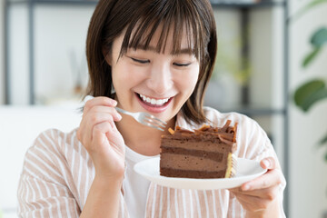 チョコレートケーキを食べる若い女性