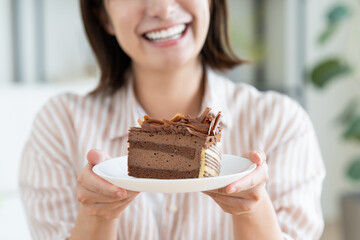 チョコレートケーキを食べる若い女性