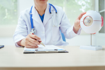 A male doctor wearing glasses sits at a desk in a hospital, explaining eye diseases like glaucoma, cataracts, pterygium, and diabetic retinopathy. Early detection helps prevent vision loss