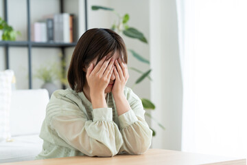 リビングで悩む若い女性