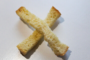 close-up of crunchy strips of white bread that has gluten in an X formation isolated on a white
