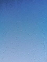 Water droplets on the window glass against the blue sky background. Summer rain. The rainy season....