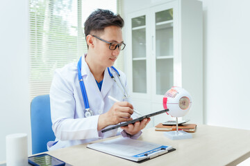 A male doctor wearing glasses sits at a desk in a hospital, explaining eye diseases like glaucoma, cataracts, pterygium, and diabetic retinopathy. Early detection helps prevent vision loss