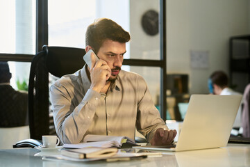 Young confident male chief executive officer or director of business company speaking on mobile...