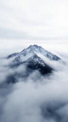 Obraz premium Majestic mountain peaks emerging through enchanting misty clouds