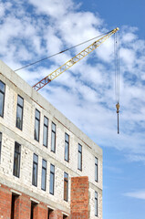 Tower crane building a house. Concrete building under construction. Construction site