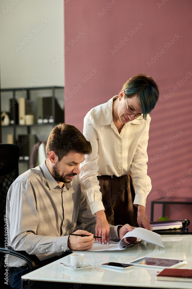 Aufkleber young secretary pointing at document while standing next to director of business company and asking 