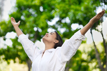 Relaxed happy refreshing young south asian woman taking a deep breath of clean unpolluted air in urban park, good summer, summer wellness, sunlight exposure concept image