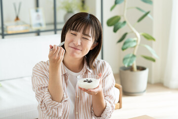 ヨーグルトを食べる若い女性