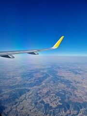 Fototapeta premium View of commercial airplane wing from window with blue sky background