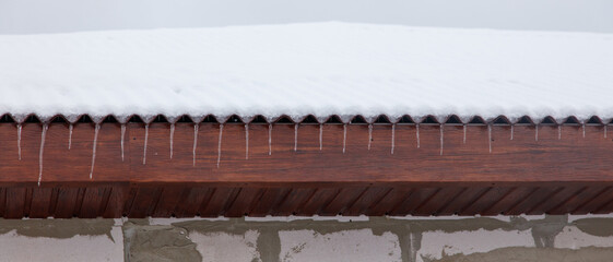 A roof covered in snow and icicles