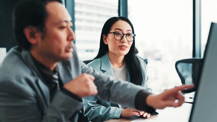 Fototapeta premium Help, manager and Asian business people on computer with feedback, review and meeting for online project. Office, corporate and worker with boss for teamwork, collaboration and discussion in Japan