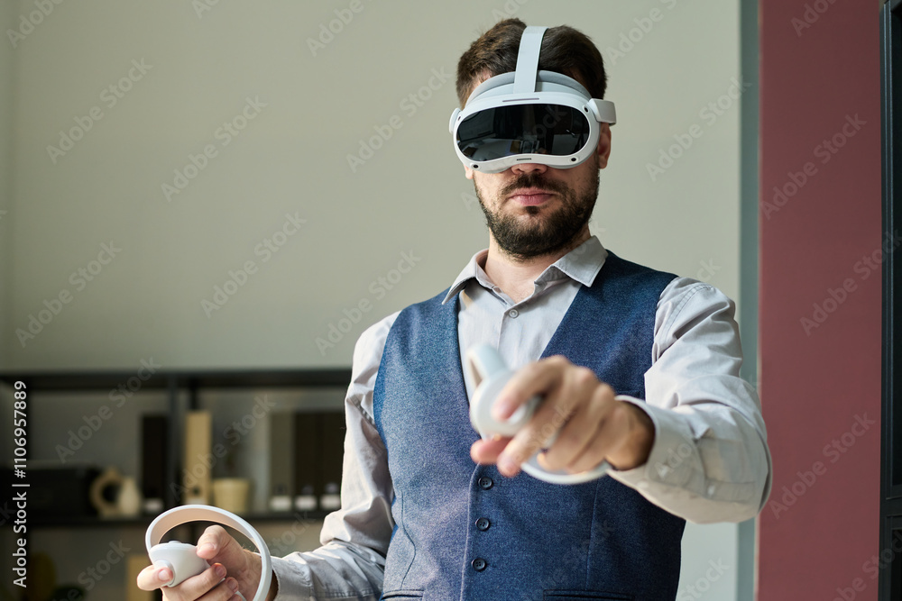 Poster Young confident male employee pointing at interactive virtual screen while making presentation or studying data in office