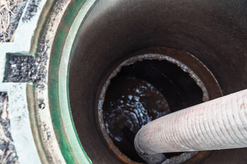 Pumping sewage. A vacuum hose extends into a green sewage tank, ready to extract waste. drainage...