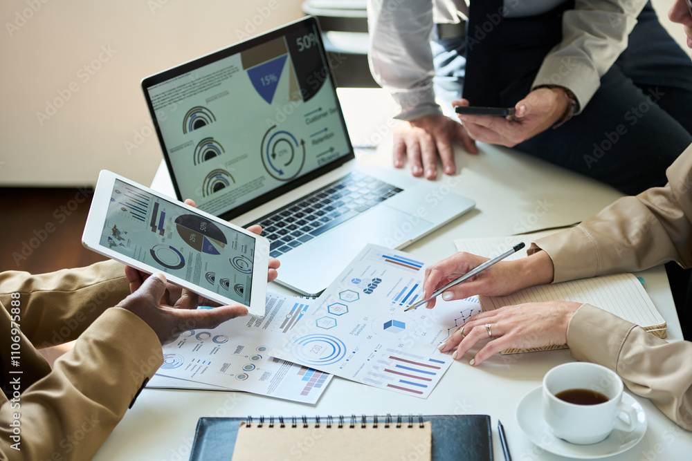 Poster hands of three unrecognizable intercultural analysts discussing documents with financial charts and 