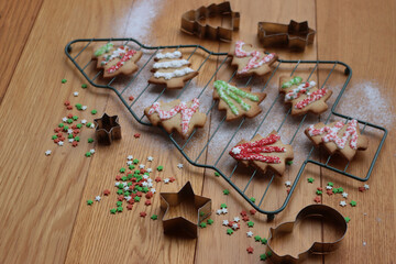 Christmas tree shaped gingerbread cookies  on a cooling rack in shape of a tree on wooden table 